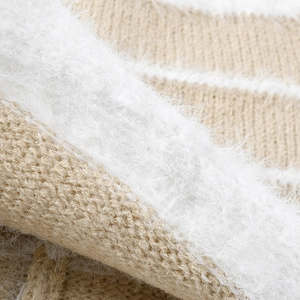 Women's winter knit beanie featuring striped beige texture and soft white faux fur detail