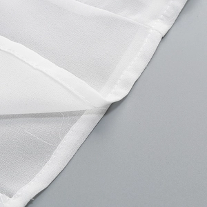 Detail eines weißen ärmellosen Kleides mit Chiffonstoff und feinen Nähten