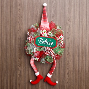 Christmas gnome wreath with red and green stripes, featuring 'Believe' text on wood background