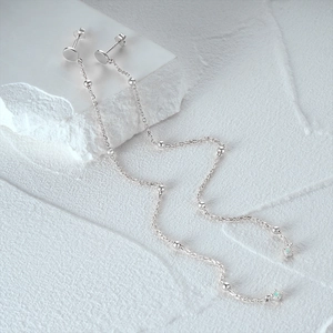 Macro detail of S925 sterling silver chain earrings featuring opal stones and metal beads