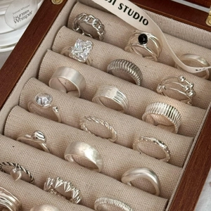 Collection of S925 sterling silver rings with various textures in a luxury jewelry box