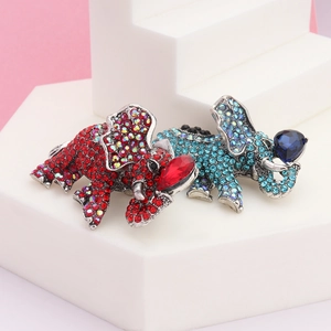 Detailed view of colorful elephant brooches with rhinestones on a white geometric stand