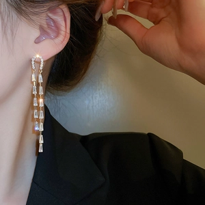 Close-up of elegant U-shaped long tassel earrings with sparkling cubic zirconia stones
