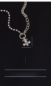 Detailed view of silver fleur-de-lis pendant with zircon stones and 925 stamp