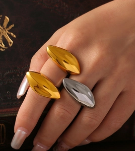 Polished 18k gold and silver geometric leaf ring styled on hand over vintage books