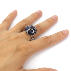Macro detail of handmade silver wire wrapped Tree of Life ring with blue sandstone