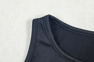 Detailed close-up of the round neckline and stitching on a black sleeveless dress