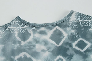 Detail of round neckline with blue and grey tie-dye print on elastic knit fabric