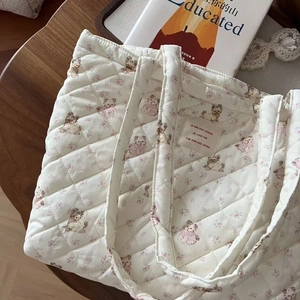 Close-up of quilted floral tote bag with cute puppy prints and minimalist fabric label