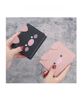 Close-up of cute cartoon pig short wallets in pink and black PU leather with heart ears