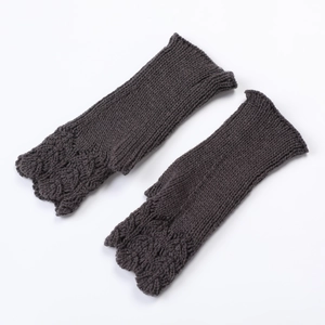 Detail of dark grey knit fingerless gloves showing the intricate scale pattern texture