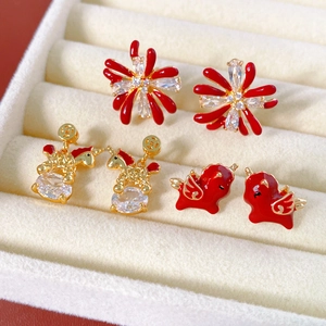 Detail of 18k gold plated unicorn and floral stud earrings with red enamel and zircons