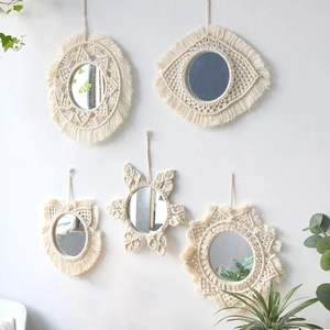 Detail of five bohemian woven cotton rope mirrors in circular and star shapes on a wall