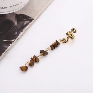 Detailed view of snake design gold ear cuff with tiger eye stone beaded tassels