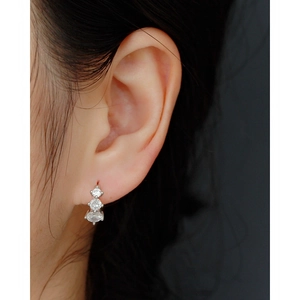 Close-up of sparkling triple zircon drop earrings in 925 sterling silver on a female model