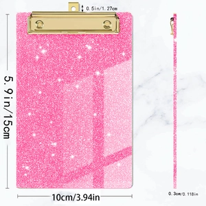 Pink glitter acrylic mini clipboard with gold metal clip showing 15x10cm dimensions