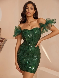 Détail d'une robe verte à paillettes avec manches à volants en tulle et texture brillante