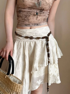 Detail of bohemian acrylic geometric beads and woven waist chain on a tiered skirt
