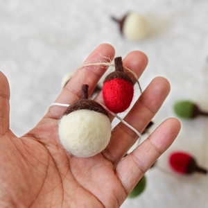 Handcrafted wool felt acorn garland in red, white and green for Christmas decoration