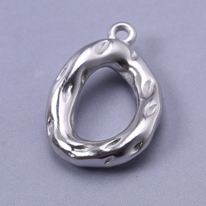 Macro shot of silver irregular oval teardrop pendant with textured stainless steel finish