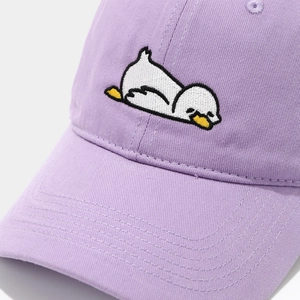 Detail of embroidered cartoon white duck on a lavender cotton twill baseball cap