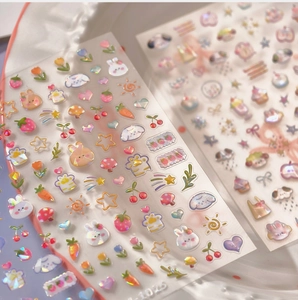 Detailed macro view of 3D rabbit and floral nail stickers with a holographic laser finish
