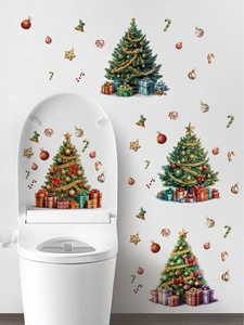 Close-up of waterproof Christmas tree and gift decals on a white bathroom toilet lid