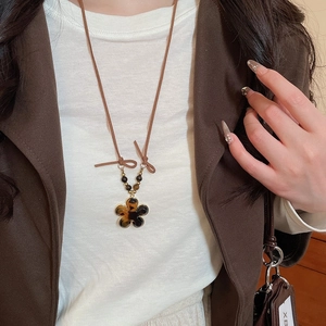 Detailed view of leopard print resin flower pendant necklace with tiger eye beads