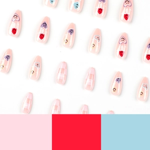Pink checkerboard press-on nails with heart and smiley face designs in long almond shape