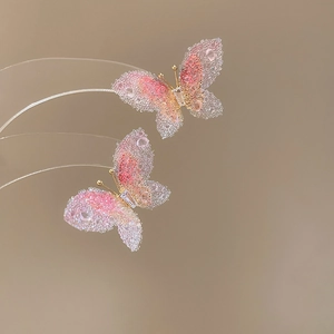 Macro shot of pink gradient butterfly earring with sugar-textured finish and inlaid rhinestones