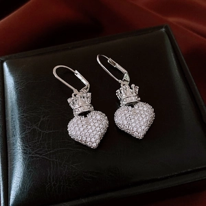 Vue macro de boucles d'oreilles cœur couronne avec zircons sur cuir noir