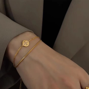 Close-up of double-layered gold titanium steel bracelet featuring a round character pendant