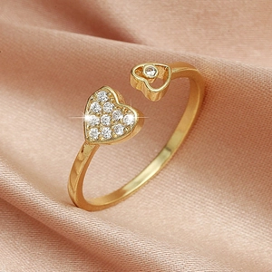 Detailed macro view of heart-shaped gold ring with zircon pavé on pink silk background