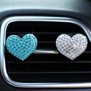 Detail view of blue and white rhinestone heart car air vent clips on AC outlet