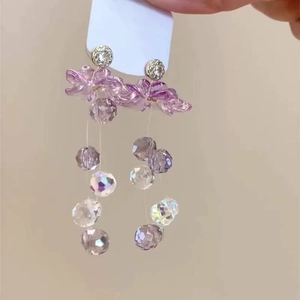 Close-up detail view of sweet pink flower earrings with elegant purple crystal bead dangles