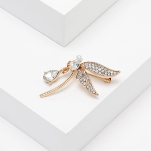 Detailed view of dragonfly brooch featuring sparkling crystals and a central pearl accent