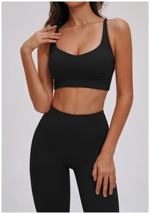 Detail van zwarte sportbeha met gekruiste bandjes en bijpassende legging met hoge taille