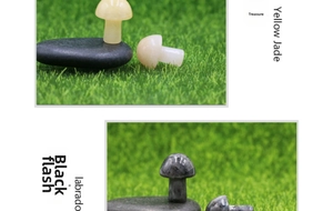 Miniature mushroom carvings in yellow jade and labradorite stones on grass