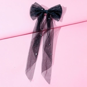 Detailed close-up of a large black tulle bow hair clip with elegant pearl accents