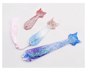 Detailed view of cat-shaped resin bookmarks with glitter powder and pink silk tassels