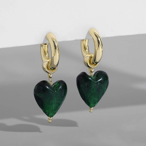 Détail de boucles d'oreilles cœur vintage avec cercles dorés et breloques cœur vert foncé