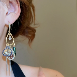 Macro shot of vintage teardrop earrings with zircon accents and colorful mosaic tassels