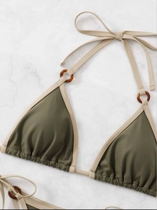 Detail of olive green triangle bikini top with tortoise shell rings and beige ties