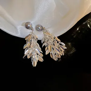 Boucles d'oreilles pampilles feuilles argentées avec perles bleu-gris sur fond de soie