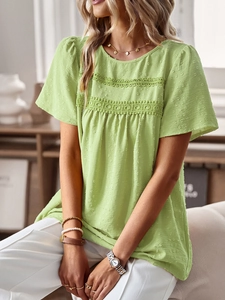 Detailed view of green puff sleeve top with Swiss dot texture and lace embroidery trim