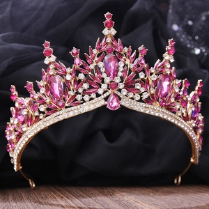 Macro shot of bridal crystal crown with pink gemstones and gold metal leaf design