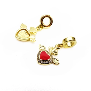 Macro view of gold winged heart charm with red enamel and pavé zircon detailing
