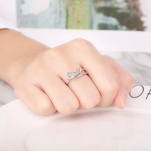 Detail of silver bow ring with sparkling crystals shown on hand in a soft home setting