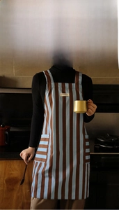 Detail of vintage striped kitchen apron with Be Original label and practical side pockets