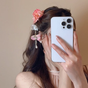 Détail d'une pince à cheveux en fleurs de soie avec pampille de perles sur modèle